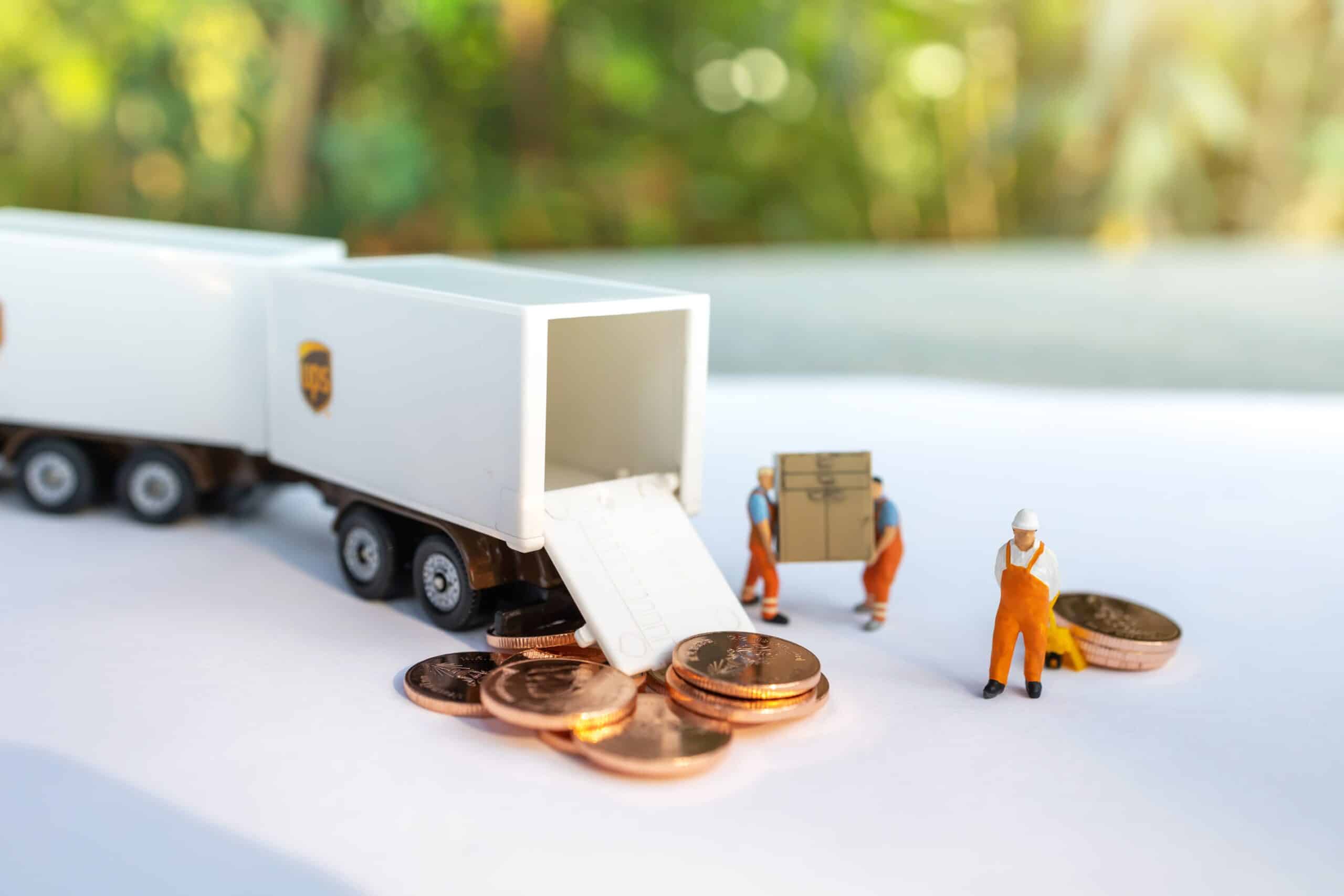 miniatyrfigurer som transporterar mynt i lastbilar